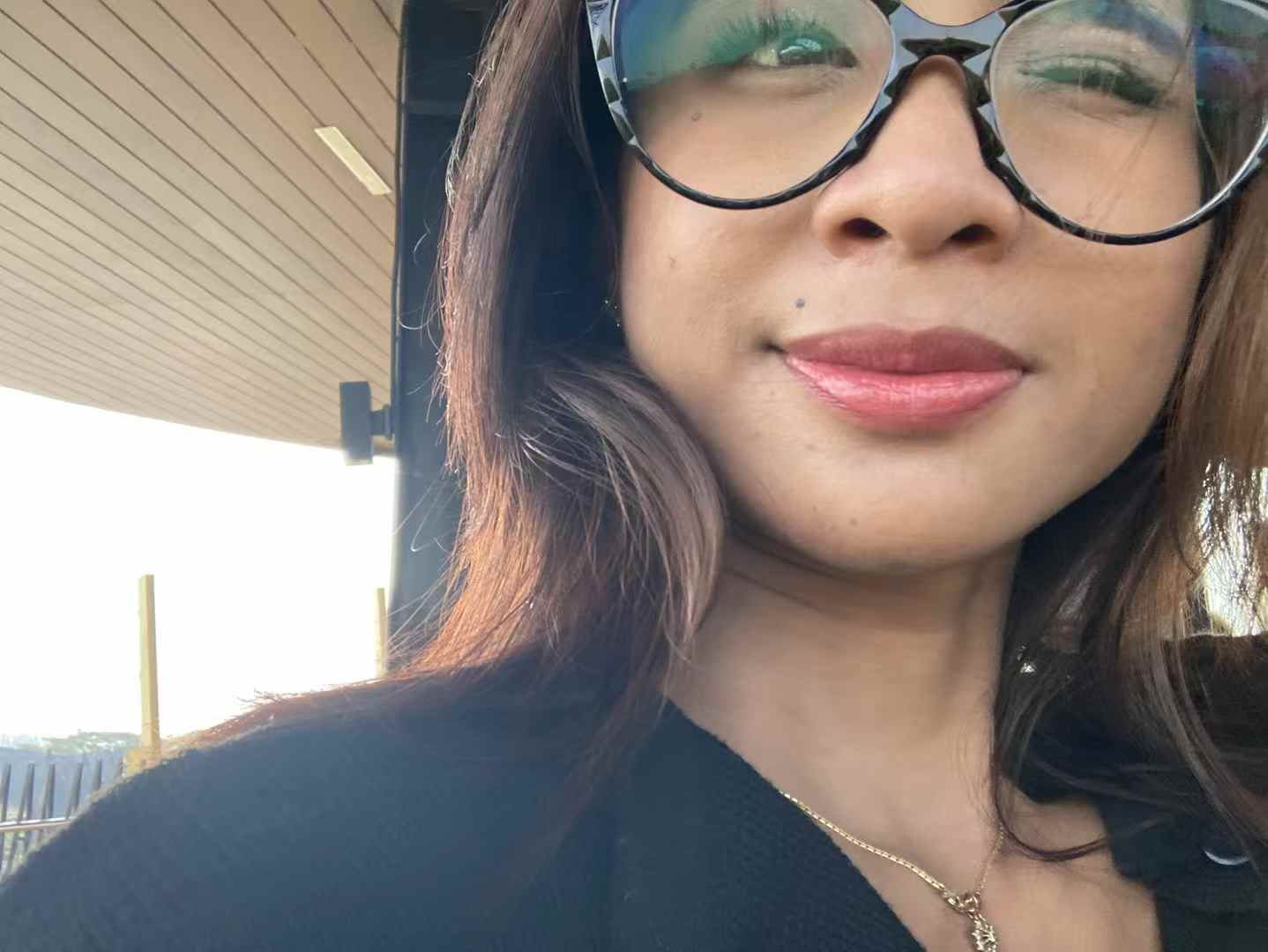 Hana Radifa berdiri di depan jendela dengan cahaya hangat